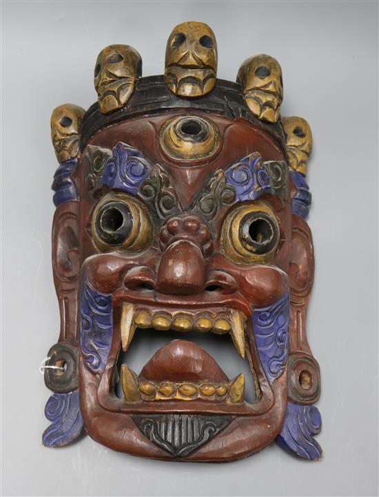 A Tibetan carved wood mask length 44cm approx.